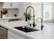 Modern kitchen island with a sink and black and gold faucet at 20437 W White Rock Rd, Buckeye, AZ 85396