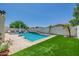Backyard showcasing a pool, waterfall feature, and grassy area at 20437 W White Rock Rd, Buckeye, AZ 85396