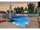 Stunning backyard oasis featuring a sparkling pool with waterfall and inviting fire pit at 20437 W White Rock Rd, Buckeye, AZ 85396