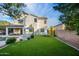 Spacious backyard with artificial grass, lounge area, pool access, and outdoor ping pong table at 2056 E Carob Dr, Chandler, AZ 85286