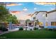 Spacious backyard with pool, spa, rock waterfall, covered patio, seating, and a ping pong table at 2056 E Carob Dr, Chandler, AZ 85286