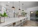 Spacious kitchen island with barstool seating, stylish pendant lighting, and views of the outdoor pool at 2056 E Carob Dr, Chandler, AZ 85286
