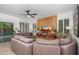 Spacious living room with a modern media wall and views of the outdoor pool through shuttered windows at 2056 E Carob Dr, Chandler, AZ 85286