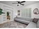 Bright living room features a modern ceiling fan, light gray sofa, and stylish decor at 2056 E Carob Dr, Chandler, AZ 85286