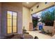 Covered patio featuring stone accents, stylish outdoor seating, and serene views of the desert landscaping at 2056 E Carob Dr, Chandler, AZ 85286