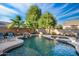 Backyard pool features tropical landscaping, a rock waterfall, a built-in spa, and inviting lounge areas at 2056 E Carob Dr, Chandler, AZ 85286