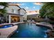 Spacious pool with spa, rock waterfall, outdoor seating, and a covered patio at 2056 E Carob Dr, Chandler, AZ 85286