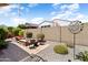 View of a backyard that includes a patio with fire pit and seating surrounded by mature desert landscaping at 20684 W Meadowbrook Ave, Buckeye, AZ 85396