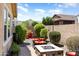 Private backyard area with a stone fire pit and outdoor seating nestled amid desert landscaping and desert trees at 20684 W Meadowbrook Ave, Buckeye, AZ 85396