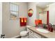 Well-lit bathroom featuring a sink with a neutral quartz countertop and colorful orange and yellow towels at 20684 W Meadowbrook Ave, Buckeye, AZ 85396