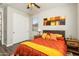 Bedroom with dark wood accents, featuring neutral walls and orange bedding at 20684 W Meadowbrook Ave, Buckeye, AZ 85396