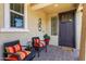 Cozy front porch with two chairs, cushions, and a decorative metal wall sculpture at 20684 W Meadowbrook Ave, Buckeye, AZ 85396