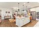 Open concept kitchen with island seating, granite countertops, stainless appliances, and seamless flow to dining area at 20684 W Meadowbrook Ave, Buckeye, AZ 85396