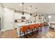 Bright kitchen with white cabinets, granite countertops, stainless steel appliances, and island seating with pendant lights at 20684 W Meadowbrook Ave, Buckeye, AZ 85396