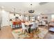 Open-concept kitchen flows to dining area with island seating and a modern dining table with pendant lights at 20684 W Meadowbrook Ave, Buckeye, AZ 85396