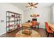 Cozy home office with wood desk, stylish shelving, a comfortable chair, and a warm, inviting atmosphere at 20684 W Meadowbrook Ave, Buckeye, AZ 85396