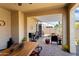 Relaxing covered patio featuring a dining table and chairs, with a stone-paved floor and view of backyard at 20684 W Meadowbrook Ave, Buckeye, AZ 85396