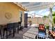 Covered patio with table, chairs, decor and a view of the fenced-in backyard with desert landscaping at 20684 W Meadowbrook Ave, Buckeye, AZ 85396