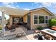 An outdoor patio with furniture, decor, and a fire pit, offering a perfect relaxation spot with shade and desert landscaping at 20684 W Meadowbrook Ave, Buckeye, AZ 85396