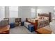 Comfortable bedroom with large windows offering lots of natural light, wood furniture, and carpeted flooring at 23112 E Twilight Dr, Queen Creek, AZ 85142