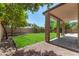 Backyard featuring a lawn, covered patio, basketball hoop, trees, and gravel beds at 2461 E Stephens Pl, Chandler, AZ 85225