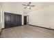This bedroom has wood-style tile and closet with four dark-colored doors at 2461 E Stephens Pl, Chandler, AZ 85225