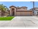 Two-story home with a three-car garage, arched entry, and desert landscaping at 2461 E Stephens Pl, Chandler, AZ 85225
