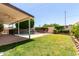 Beautiful backyard featuring a covered patio, lush lawn, a pool, and privacy landscaping at 2547 W Naranja Ave, Mesa, AZ 85202