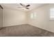 A cozy bedroom with neutral carpet, bright windows, and a modern ceiling fan at 2547 W Naranja Ave, Mesa, AZ 85202