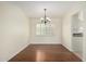 An open dining room with hardwood floors, a chandelier and plantation shutters for natural light at 2547 W Naranja Ave, Mesa, AZ 85202