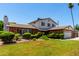 Charming two-story home featuring a well-maintained lawn, lush landscaping, and a brick facade with a two car garage at 2547 W Naranja Ave, Mesa, AZ 85202