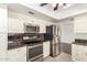 Well-equipped kitchen with stainless steel appliances, granite countertops, white cabinets and tile floor at 2547 W Naranja Ave, Mesa, AZ 85202