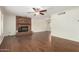 Large Living room showcasing a brick fireplace, wood floors, baseboards, neutral paint and a ceiling fan at 2547 W Naranja Ave, Mesa, AZ 85202