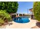 Backyard view of a sparkling pool with a slide and lush landscaping around the yard at 2547 W Naranja Ave, Mesa, AZ 85202