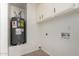 Utility room featuring tile flooring, a water heater, and white storage cabinets at 2547 W Naranja Ave, Mesa, AZ 85202