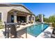 Inviting backyard featuring a sparkling pool, covered patio, and comfortable outdoor seating, perfect for relaxation and entertainment at 26314 N 103Rd Dr, Peoria, AZ 85383