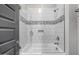 Bright bathroom with a glass enclosed bathtub and shower with white tile at 26314 N 103Rd Dr, Peoria, AZ 85383