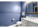 Elegant powder room boasts stylish fixtures, marble countertop, and beautiful blue wall paint at 26314 N 103Rd Dr, Peoria, AZ 85383