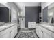 Bathroom with double granite vanity, tiled floors, and a tiled walk in shower at 26314 N 103Rd Dr, Peoria, AZ 85383