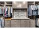 A walk-in closet with a vanity and counter, along with shelving, racks, and drawers at 26314 N 103Rd Dr, Peoria, AZ 85383