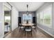 Dining room with hardwood floors, modern light fixture, slider to deck, and large window with plantation shutters at 26314 N 103Rd Dr, Peoria, AZ 85383