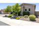 Beautifully landscaped front yard with mature trees, rock features, and healthy plants adding curb appeal at 26314 N 103Rd Dr, Peoria, AZ 85383