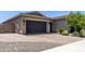 Well-maintained exterior showcasing a spacious driveway, a two-car garage, and tasteful landscaping at 26314 N 103Rd Dr, Peoria, AZ 85383