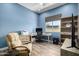 Well lit office with a fan, desk, recliner, and a mounted TV at 26314 N 103Rd Dr, Peoria, AZ 85383