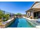 Beautiful backyard pool with stone accents, lush landscaping, and outdoor seating for entertaining at 26314 N 103Rd Dr, Peoria, AZ 85383