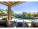 Backyard featuring a sparkling pool, covered patio, and desert landscaping at 26314 N 103Rd Dr, Peoria, AZ 85383