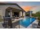 Inviting backyard oasis featuring a sparkling pool, covered patio, and comfortable lounge seating at 26314 N 103Rd Dr, Peoria, AZ 85383