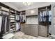 Large walk in closet with shelves, drawers, granite counter, and hanging racks at 26314 N 103Rd Dr, Peoria, AZ 85383