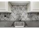 Wet bar featuring unique backsplash, stainless steel sink and faucet, and white cabinetry at 26314 N 103Rd Dr, Peoria, AZ 85383