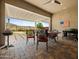 Covered back patio with an outdoor kitchen, ceiling fan, grill, and elegant seating area at 30287 N 115Th Dr, Peoria, AZ 85383